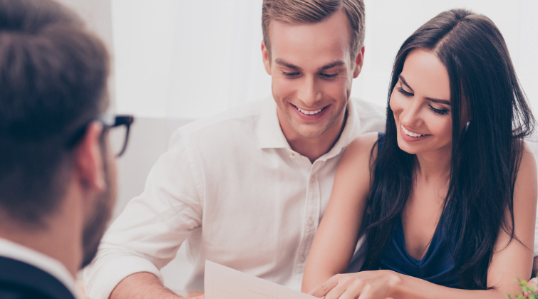 Pareja siendo asesorada sobre el pago de impuestos al comprar una vivienda